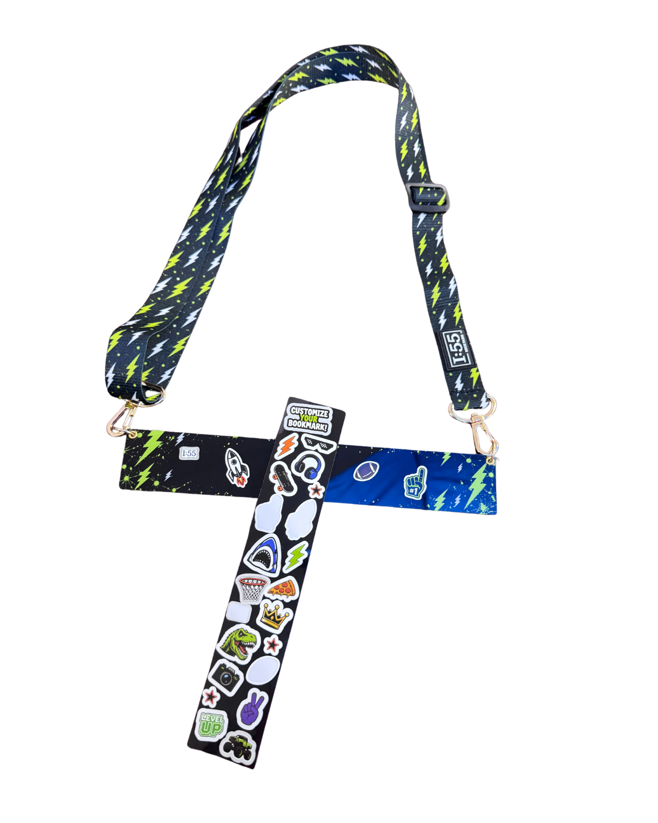 A custom book holder with a patterned strap featuring blue, green, and black shapes, adorned with various colorful stickers on the center crossbar, shown against a plain white background.